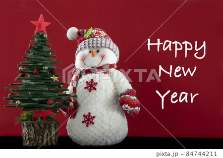 Christmas greeting background with pine tree and Snowman ornaments isolated on red surface with copy space 84744211