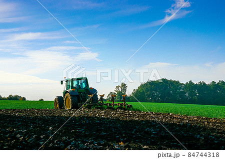 Tractor farm. Agriculture farm machinery on landscape land field. Farmer machine equipment for crop. Tractor farm fields concept. Tractor farm. Agriculture farm machinery on landscape land field. Farmer machine equipment for crop. Tractor farm fields concept. 84744318