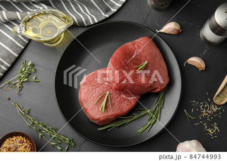 Flat lay composition with fresh beef cut on black table Flat lay composition with fresh beef cut on black table 84744993