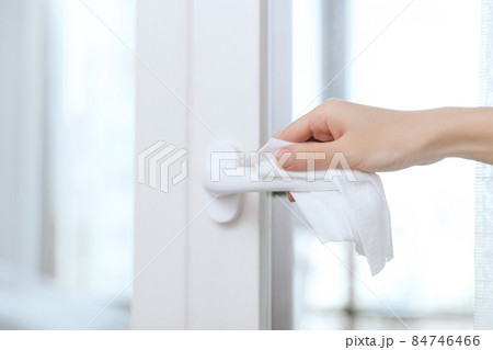 Cleaning door handles with an antiseptic wet wipe and gloves. Woman hand using towel for cleaning home room door link. Sanitize surfaces prevention in hospital and public spaces against corona virus. Cleaning door handles with an antiseptic wet wipe and gloves. Woman hand using towel for cleaning home room door link. Sanitize surfaces prevention in hospital and public spaces against corona virus. 84746466
