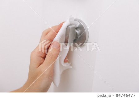 Cleaning door handles with an antiseptic wet wipe and gloves. Sanitize surfaces prevention in hospital and public spaces against corona virus. Woman hand using towel for cleaning home room door link. Cleaning door handles with an antiseptic wet wipe and gloves. Sanitize surfaces prevention in hospital and public spaces against corona virus. Woman hand using towel for cleaning home room door link. 84746477
