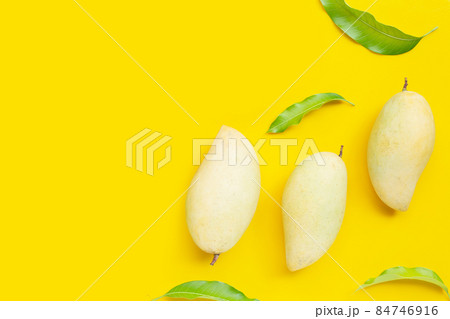 Tropical fruit, Mango with leaves on yellow background. Top view 84746916