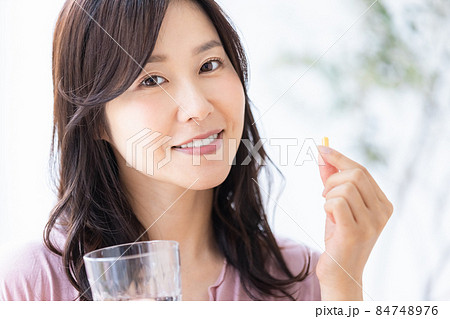 カプセル錠剤を飲む部屋着の女性 カプセル錠剤を飲む部屋着の女性 84748976