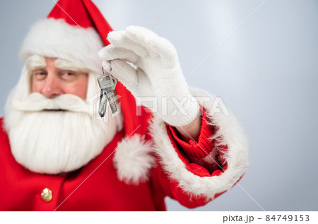 Santa Claus holds keys on a white background. New home gift for christmas. Santa Claus holds keys on a white background. New home gift for christmas. 84749153