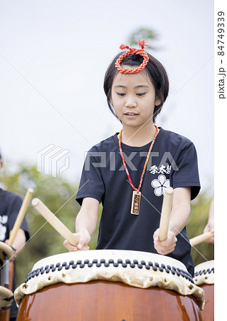 真剣に和太鼓を演奏する小学生女の子 84749339