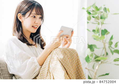 スマホで動画を観る女性 84752004