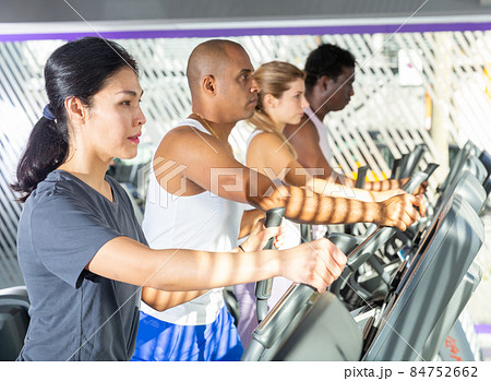 Woman training on elliptical trainer in gym 84752662