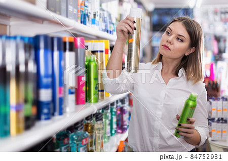 Serious young woman choosing hair care products 84752931
