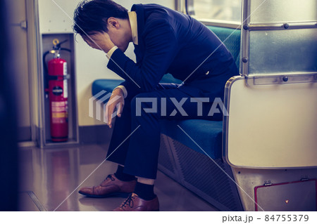 電車の車内で落ち込む男性　train 84755379