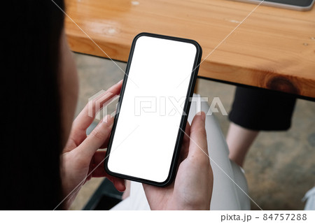 Mock up phone in woman hand showing white screen, female using mobile phone with blank screen for texting, chat. Mock up phone in woman hand showing white screen, female using mobile phone with blank screen for texting, chat. 84757288
