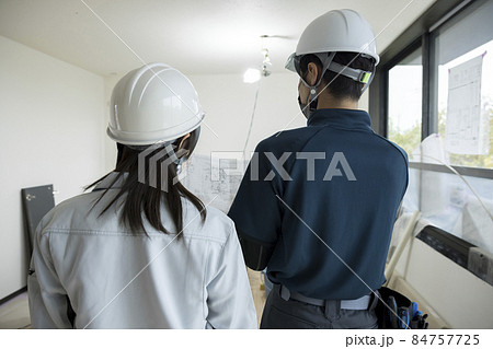 建築中の家で打ち合わせをする作業員男女 84757725