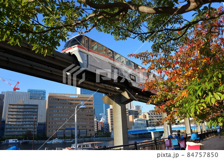 Tokyo Monorail as seen through fall color leaves from Shibaura Island in Minatoku Tokyo, Japan 84757850