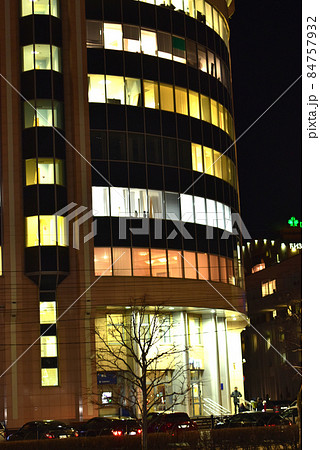 High-rise building with illuminated windows at night. 84757932