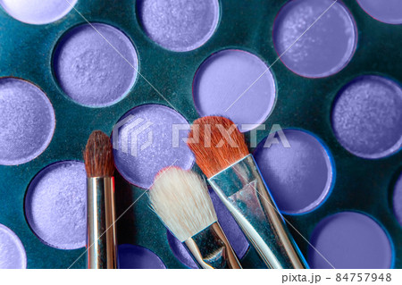 Eyeshadow palette and make up brush colored in trendy color of year 2022 Very Peri background. Flat lay top view copy space. Inspired by using color 17-3938. Color of the year concept Eyeshadow palette and make up brush colored in trendy color of year 2022 Very Peri background. Flat lay top view copy space. Inspired by using color 17-3938. Color of the year concept 84757948