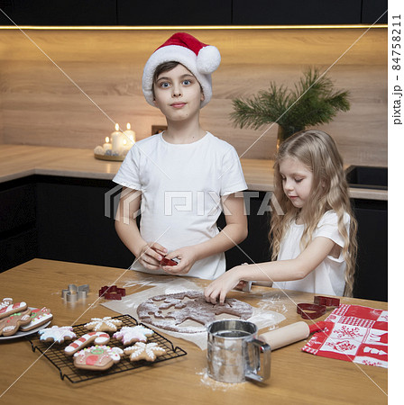 Children - a boy and a girl are preparing gingerbread in the kitchen 84758211