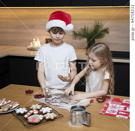 Children - a boy and a girl are preparing gingerbread in the kitchen 84758212