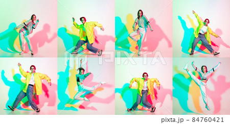 Two stylish girls, teens dancing hip-hop in stylish clothes on colored studio background with glitch effect. 84760421