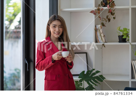 Portrait beautiful businesswoman hand with cup of coffee while standing in office room with copy space Portrait beautiful businesswoman hand with cup of coffee while standing in office room with copy space 84761334