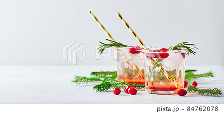 Alcoholic cocktail or non-alcoholic mocktail with vodka and iced cranberries with fir branches for christmas 84762078