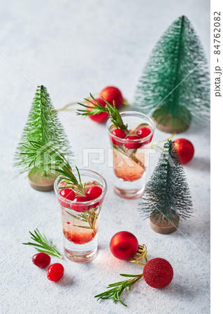 Alcoholic cocktail or non-alcoholic mocktail with vodka and cranberries in shots with fir branches for christmas Alcoholic cocktail or non-alcoholic mocktail with vodka and cranberries in shots with fir branches for christmas 84762082