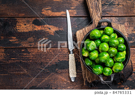 Boiled Brussels green sprouts cabbage in a pan. Dark wooden background. Top view. Copy space 84765331