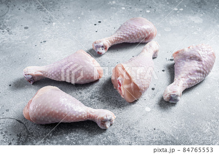 Raw uncooked chicken legs, drumsticks on stone table. Gray background. Top view 84765553