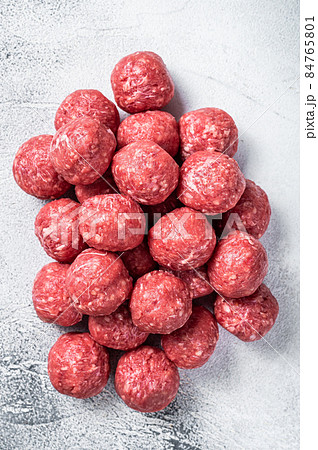 Uncooked Raw beef and pork meatballs with spices on kitchen table. White background. Top view 84765801