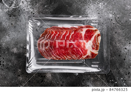 Cured meat coppa pack, on black dark stone table background, top view flat lay, with copy space for text Cured meat coppa pack, on black dark stone table background, top view flat lay, with copy space for text 84766325