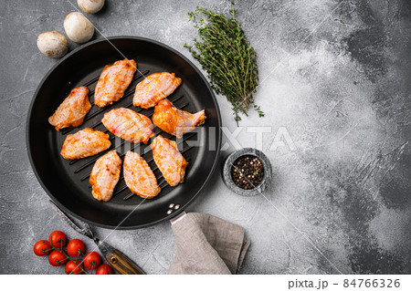 Chicken meat wings marinated and legs for BBQ, on gray stone table background, top view flat lay, with copy space for text Chicken meat wings marinated and legs for BBQ, on gray stone table background, top view flat lay, with copy space for text 84766326