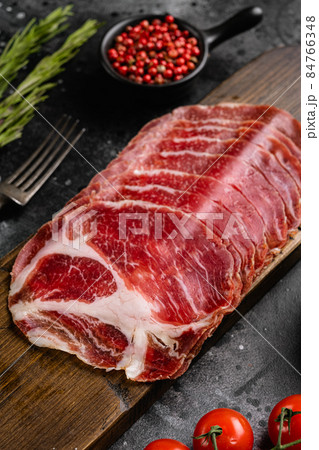Sliced cured coppa ham, on black dark stone table background Sliced cured coppa ham, on black dark stone table background 84766348