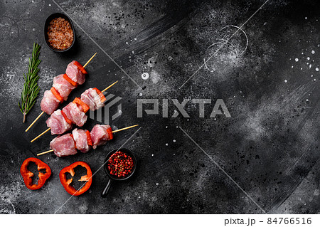 Marinated raw kebab on skewers, top view flat lay, with copy space for text, on black dark stone table background Marinated raw kebab on skewers, top view flat lay, with copy space for text, on black dark stone table background 84766516