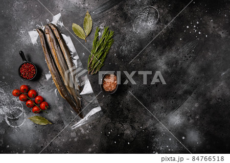 Fried river lamprey vacuum pack, on black dark stone table background, top view flat lay, with copy space for text 84766518