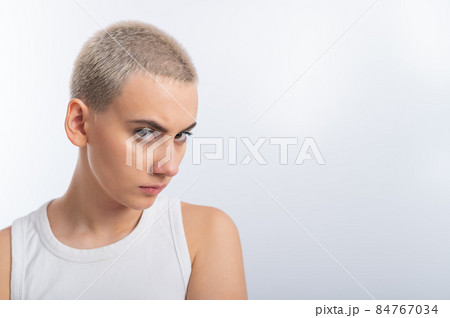 Displeased young caucasian woman with short haircut on white background. 84767034