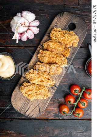 Spicy deep fried breaded chicken wings on dark wooden background, top view 84767670