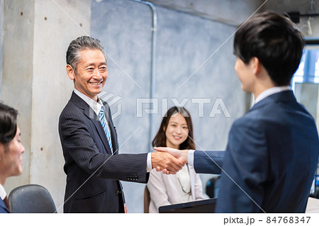 笑顔で握手をするビジネスパーソン 84768347