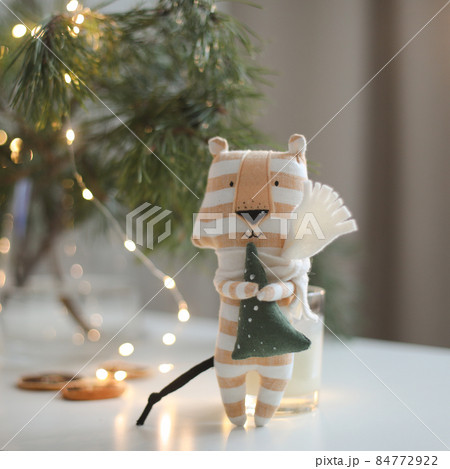 cute soft toy tiger with decorations on a cozy Christmas or New Year background. symbol of 2022, oriental calendar concept cute soft toy tiger with decorations on a cozy Christmas or New Year background. symbol of 2022, oriental calendar concept 84772922