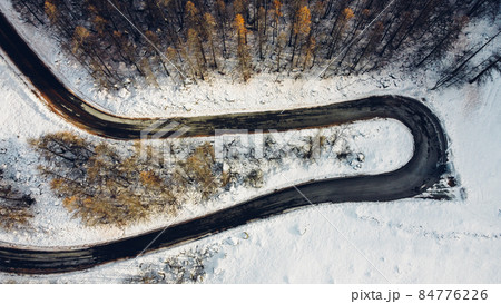 Aerial high angle view of narrow curvy road. Aerial high angle view of narrow curvy road. 84776226
