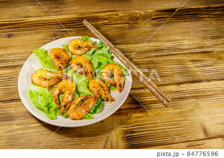 Tasty baked shrimps on a wooden table Tasty baked shrimps on a wooden table 84776596