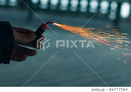 Burning Firecracker with Sparks. Guy Holding a Petard in a Hand Burning Firecracker with Sparks. Guy Holding a Petard in a Hand 84777564