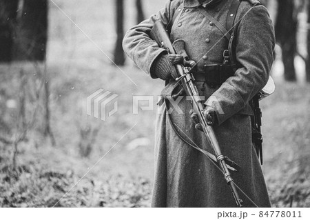 Close up of German military ammunition of a German soldier at World War II. Warm autumn clothes, soldier's overcoat, gloves, rifle. Black And White Photo. WWII Copy Space 84778011