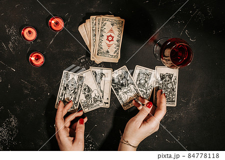 Tarot cards and female hands of fortune teller on black magic table Tarot cards and female hands of fortune teller on black magic table 84778118