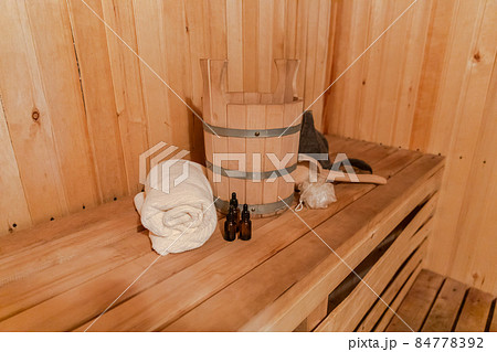 Traditional old Russian bathhouse SPA Concept. Interior details Finnish sauna steam room with traditional sauna accessories set basin towel aroma oil scoop felt. Relax country village bath concept Traditional old Russian bathhouse SPA Concept. Interior details Finnish sauna steam room with traditional sauna accessories set basin towel aroma oil scoop felt. Relax country village bath concept 84778392