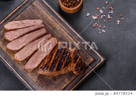 Cooked grilled Chuck eye roll steak on a chopping Board Cooked grilled Chuck eye roll steak on a chopping Board 84778524
