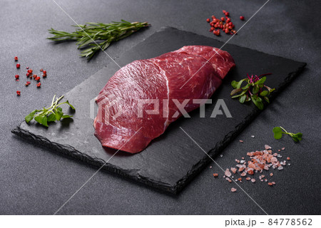 Raw fresh Chuck roll steak with herbs and salt on a cutting Board 84778562
