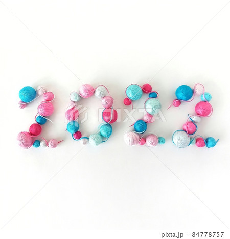 New Year 2022. Blue and pink balls of knitted yarn New Year 2022. Blue and pink balls of knitted yarn 84778757