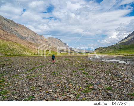 Long solo hike in the highlands. Heavy climb in the mountains with a big backpack. Travel lifestyle, hiking hard track, adventure concept in summer vacation. 84778819