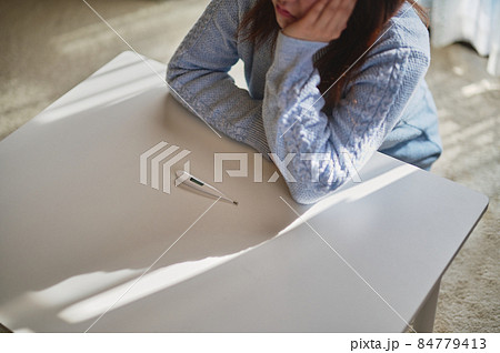 風邪をひいて熱が出ている女性 風邪をひいて熱が出ている女性 84779413