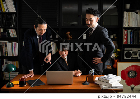 パソコンをみながら考えるチームで仕事をしている日本人ビジネスマンたち 84782444
