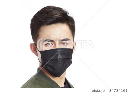 young asian man wearing black mask staring at camera, isolated on white background. young asian man wearing black mask staring at camera, isolated on white background. 84784161