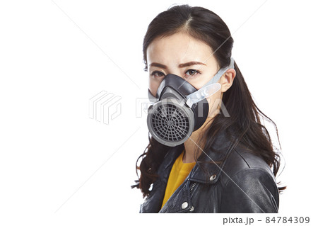 young asian woman in black leather jacket wearing a gas mask looking at camera, isolated on white young asian woman in black leather jacket wearing a gas mask looking at camera, isolated on white 84784309